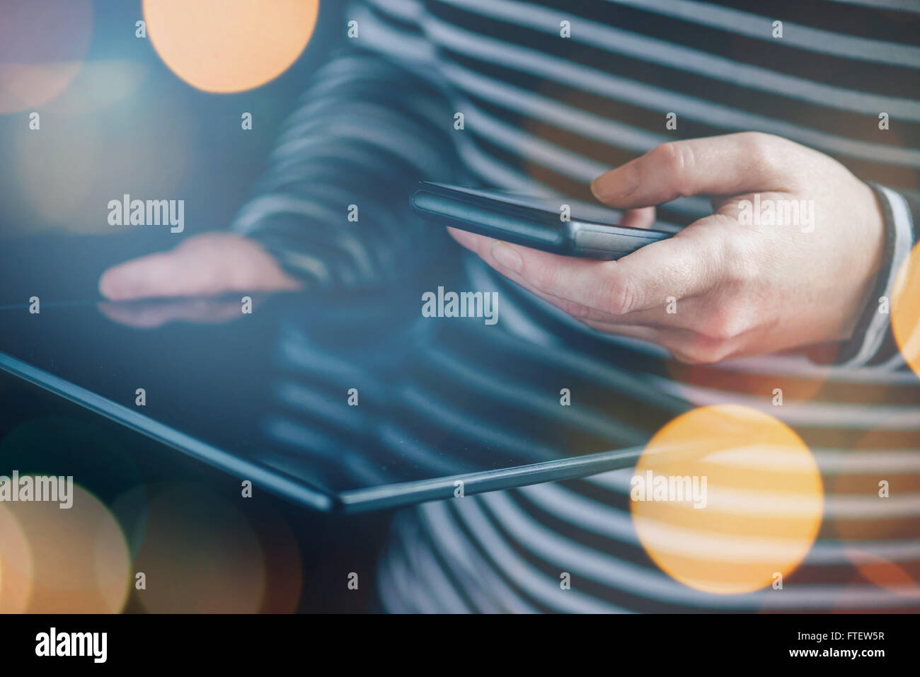 Smartphone e Tablet la sincronizzazione dei dati, la donna la sincronizzazione di file e documenti su personal wireless dispositivi elettronici a casa, s Foto Stock