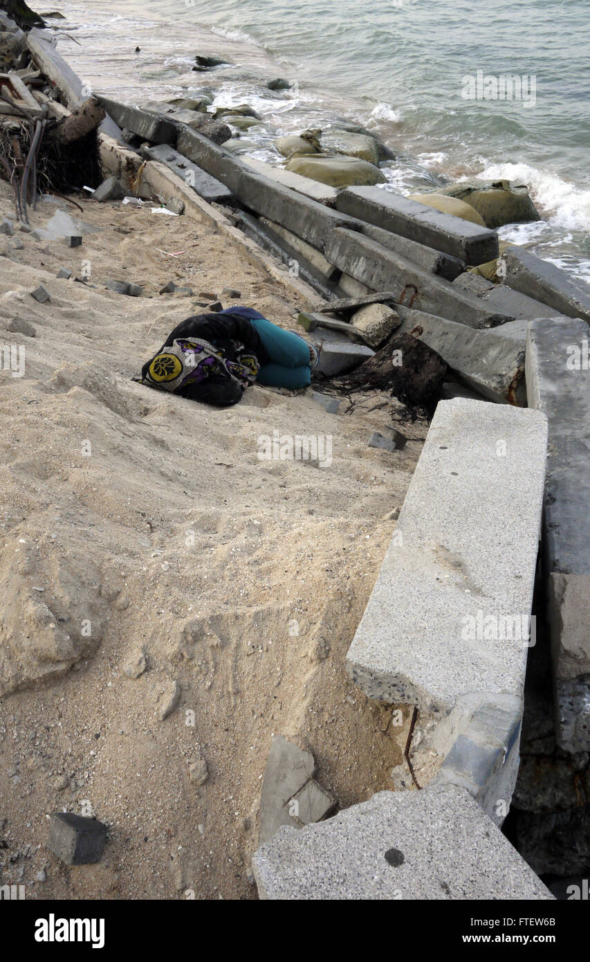 Senzatetto vagrant sonno agitato vicino al litorale danneggiato il sentiero causato da erosione del mare a Pattaya Thailandia Foto Stock