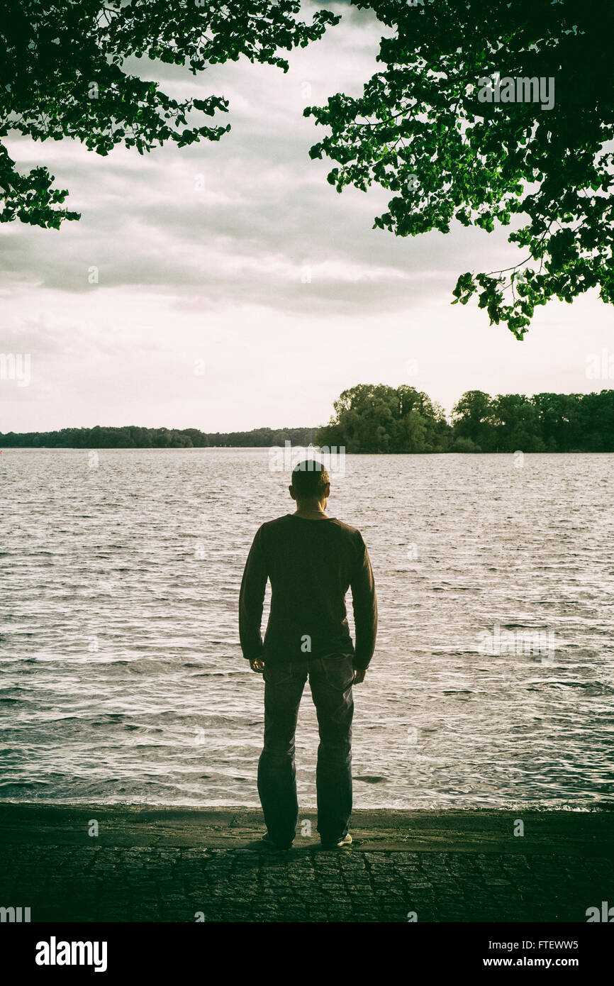 Uomo in piedi in riva al lago Foto Stock