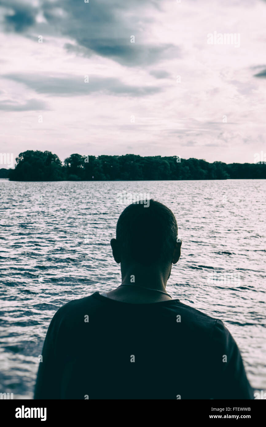 Uomo in piedi in riva al lago Foto Stock