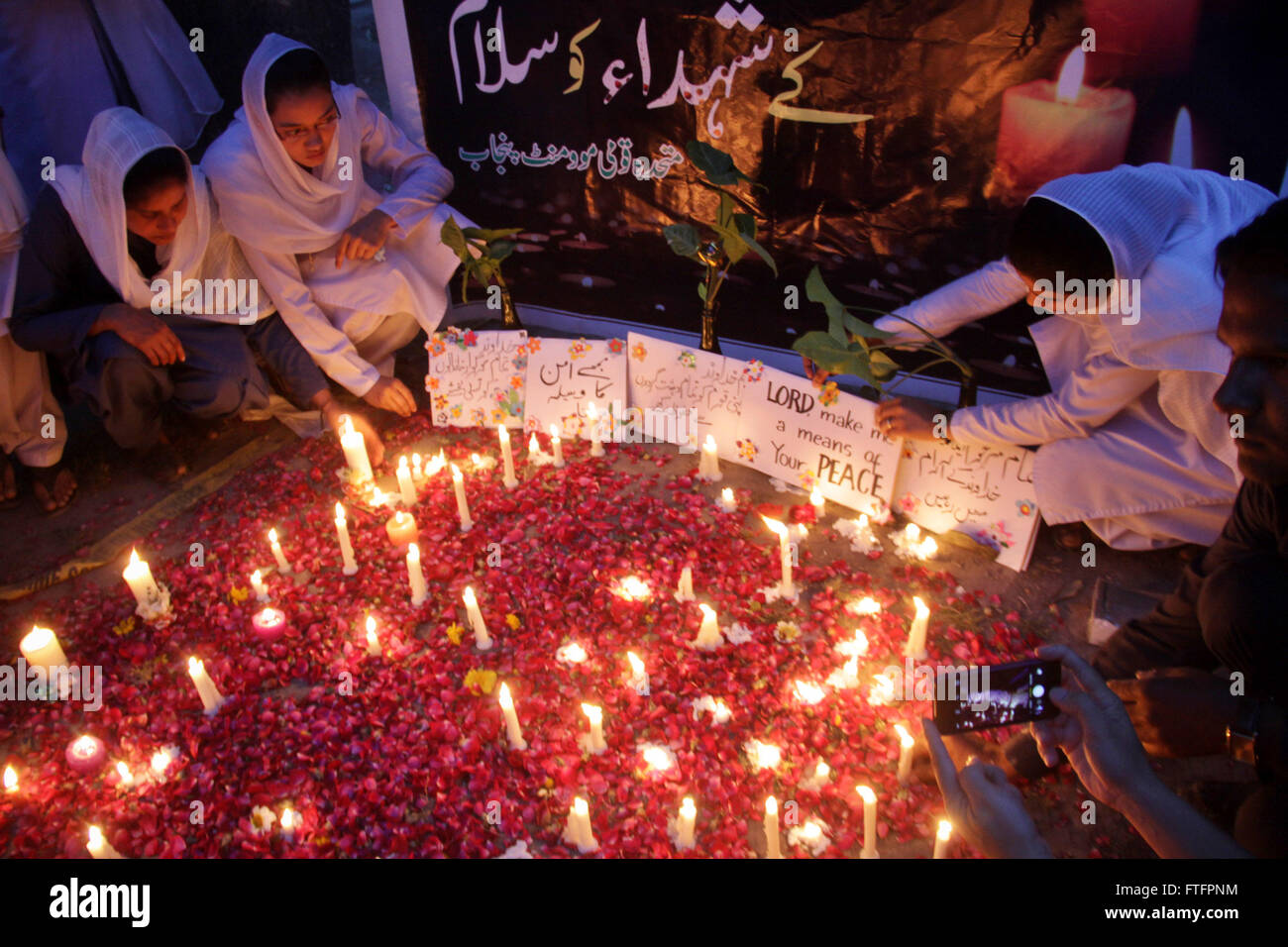 (160328) -- LAHORE, 28 marzo 2016 (Xinhua) -- la popolazione pakistana accendono le candele per suicidio blast delle vittime nel corso di una cerimonia di veglia in Pakistan orientale di Lahore il 28 marzo 2016. Almeno 72 persone sono state uccise in un esplosione di domenica notte che ha sconvolto un parco a Lahore dove il popolo cristiano sono state celebrando la Pasqua Festa. (Xinhua/Jamil Ahmed) Foto Stock