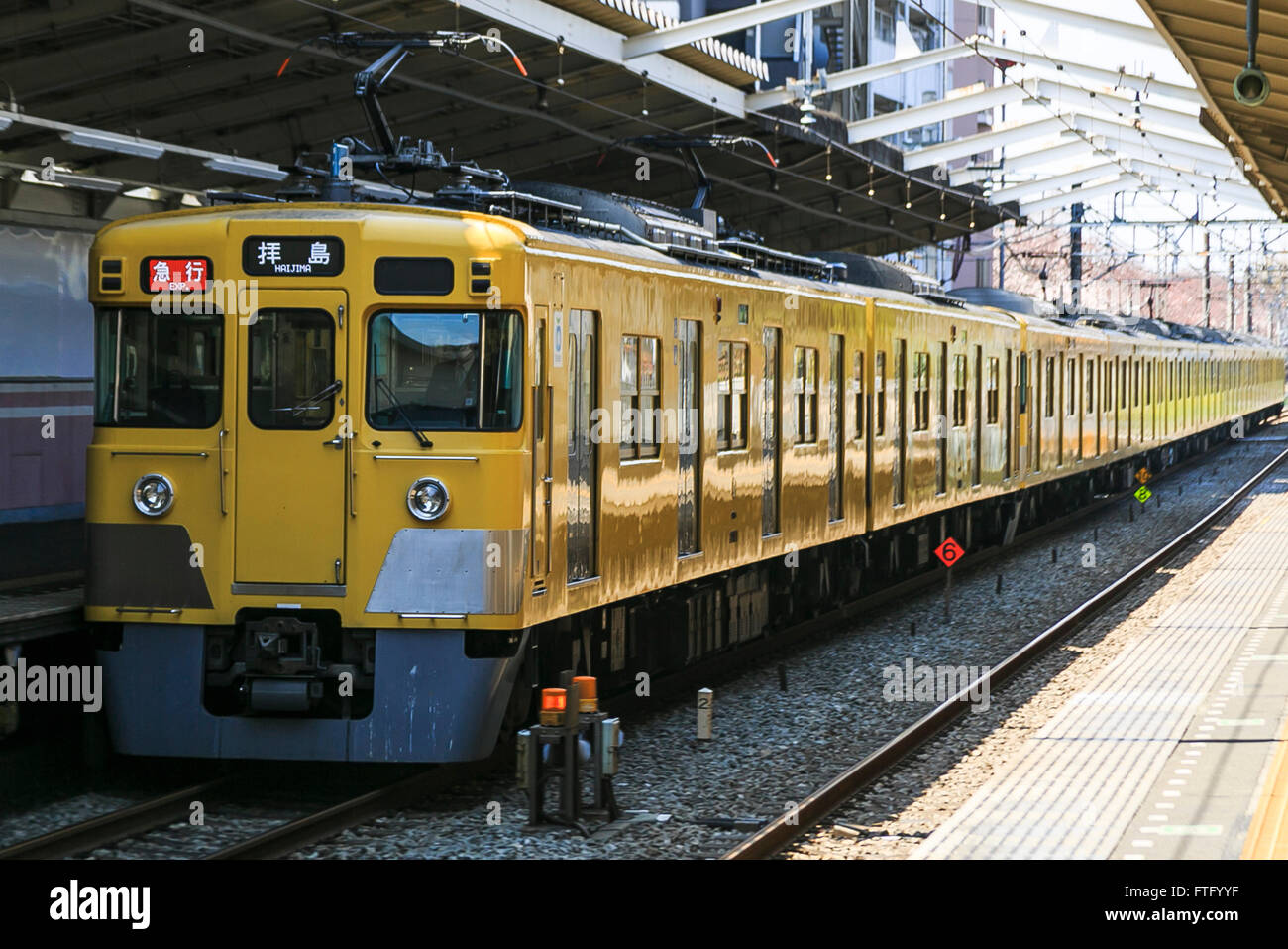 Un giallo Seibu treno lascia la stazione Musashi-Seki, 29 marzo 2016, Tokyo, Giappone. Seibu Railway Corporation ha annunciato che si affitta intera carrelli per gruppi di partito, sulla sua Seibu Shinjuku, Ikebukuro, Hajima e linee di Kokubunji, permettendo al gruppo di scegliere quale stazione di essere prelevati e riaccompagnati a. Lo speciale servizio party è rivolto a gruppi di alunni specialmente quelli che precedentemente studiato e commutato lungo una delle linee. In collaborazione con Syoya Inc., una società specializzata nell'organizzazione alumni parti, il treno società sta prendendo le prenotazioni tramite fino a maggio per Foto Stock