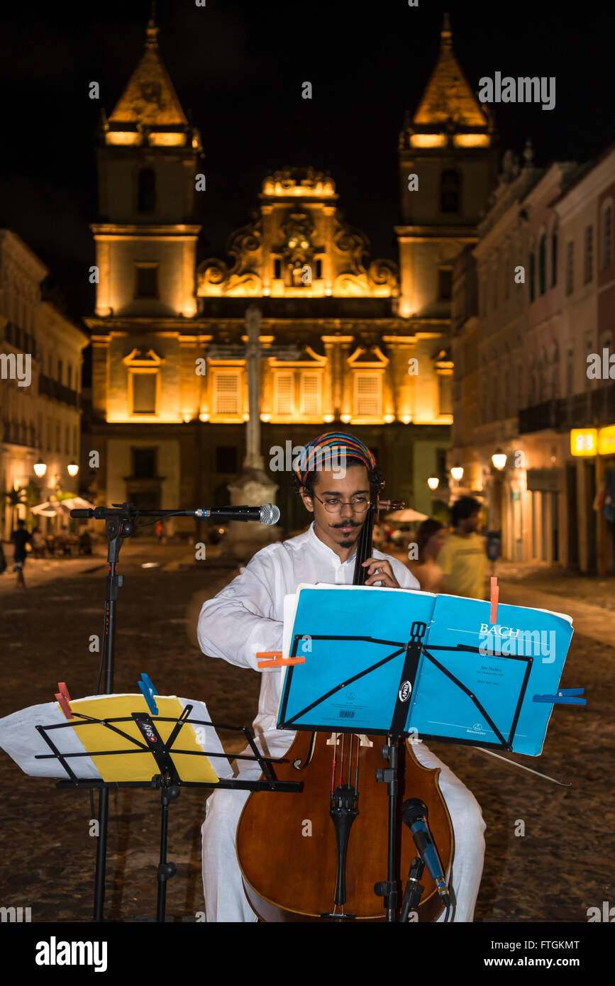 Musicista Classico suono del violoncello con la Chiesa di San Francesco in background, Salvador, Bahia, Brasile Foto Stock