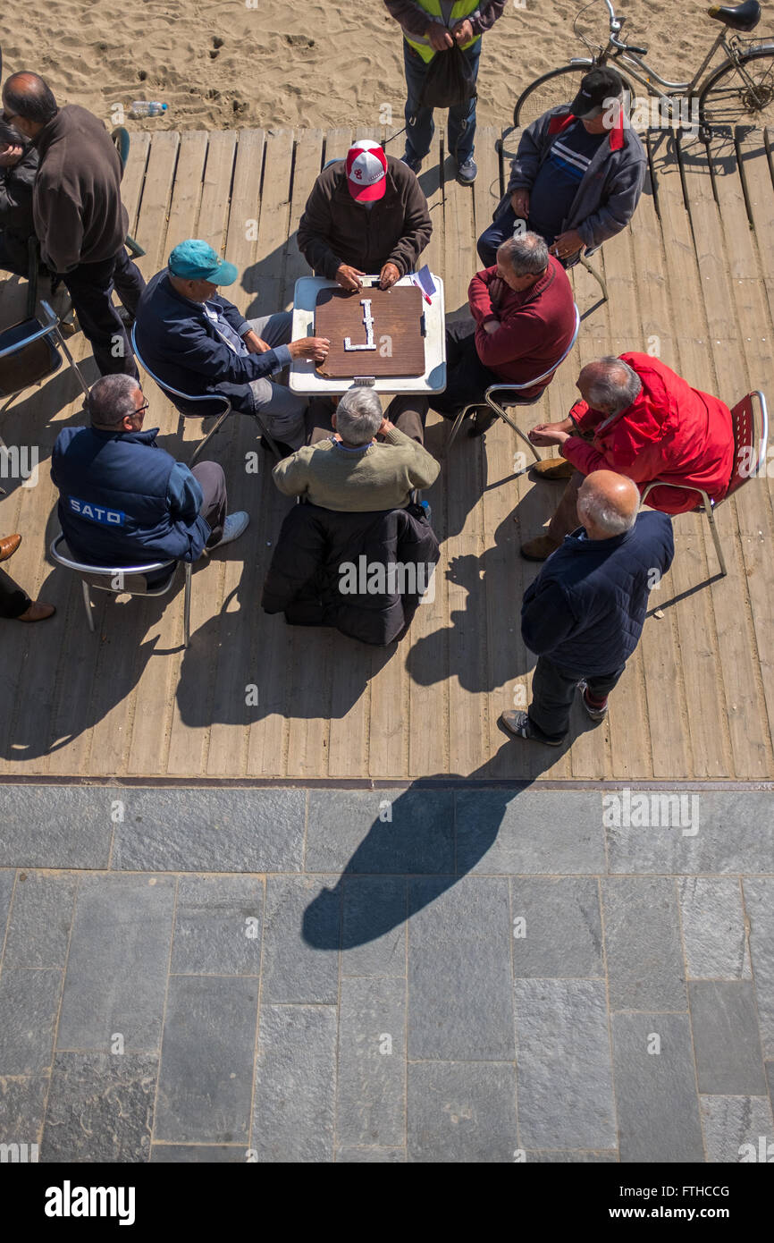 Gli uomini anziani gioca domino a Barceloneta Beach a Barcellona Foto Stock