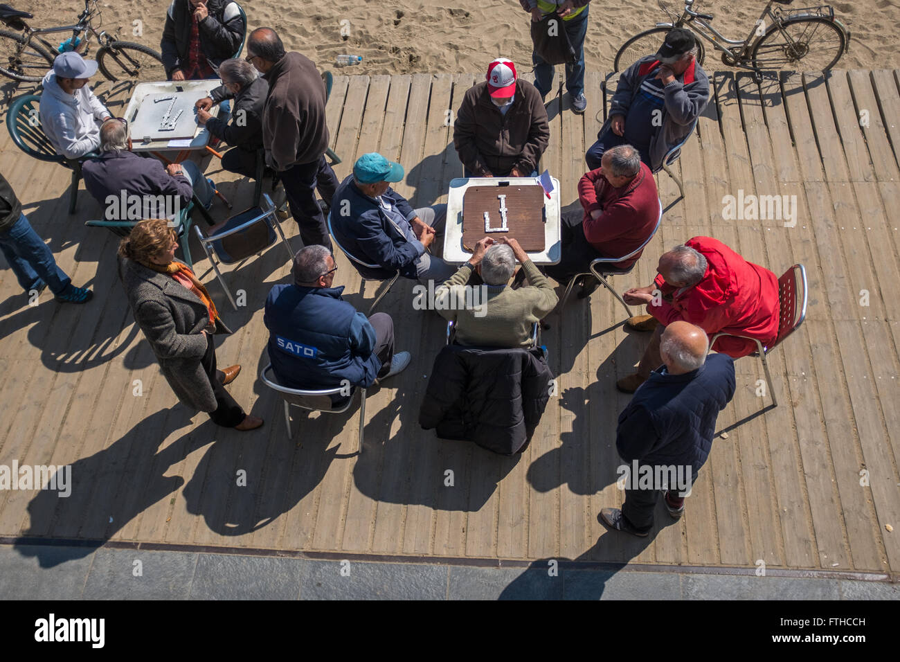 Gli uomini anziani gioca domino a Barceloneta Beach a Barcellona Foto Stock