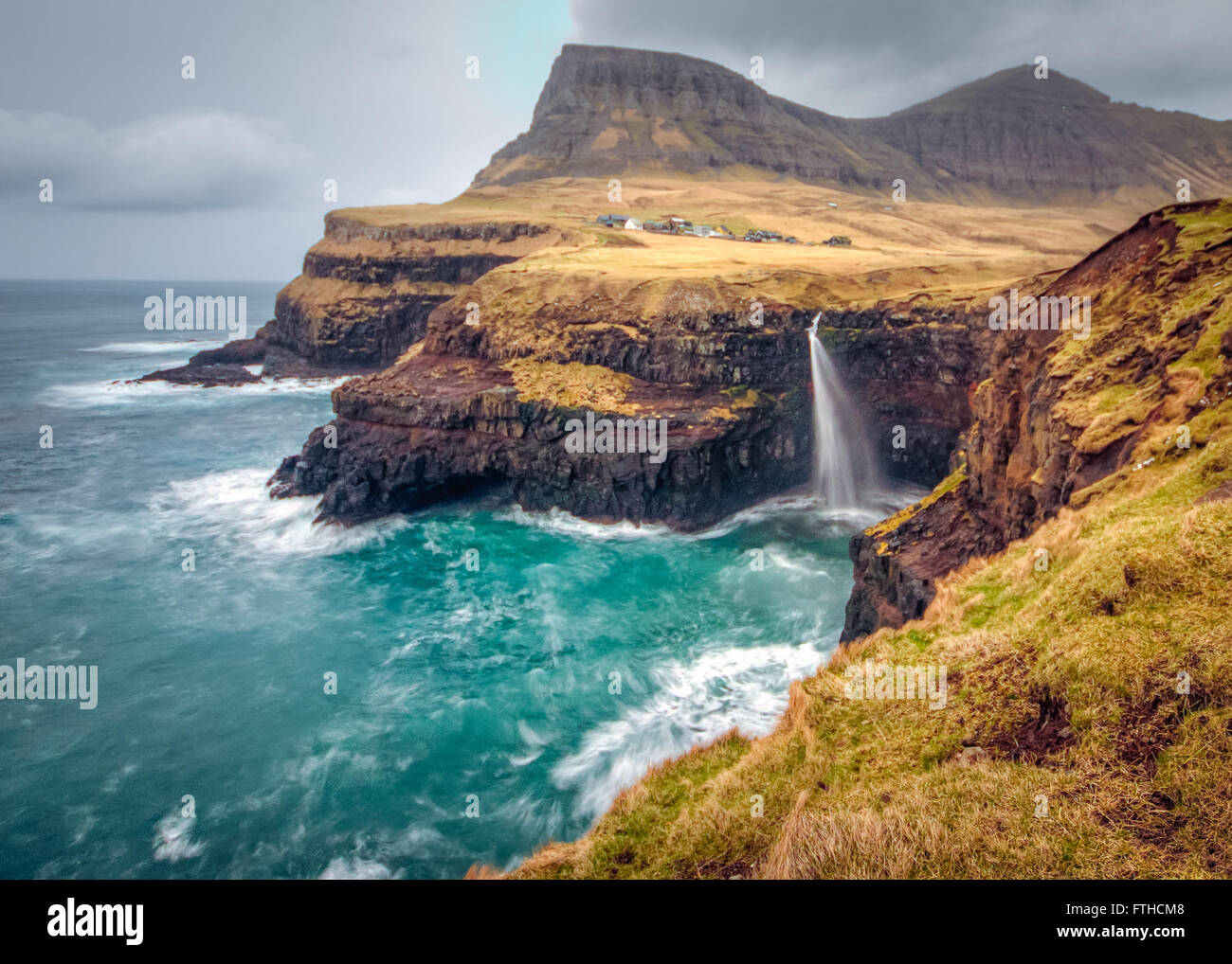 Gasadalur villaggio e la sua leggendaria cascata, funzionario ministeriale, Isole Faerøer, Danimarca. Lunga esposizione. Foto Stock