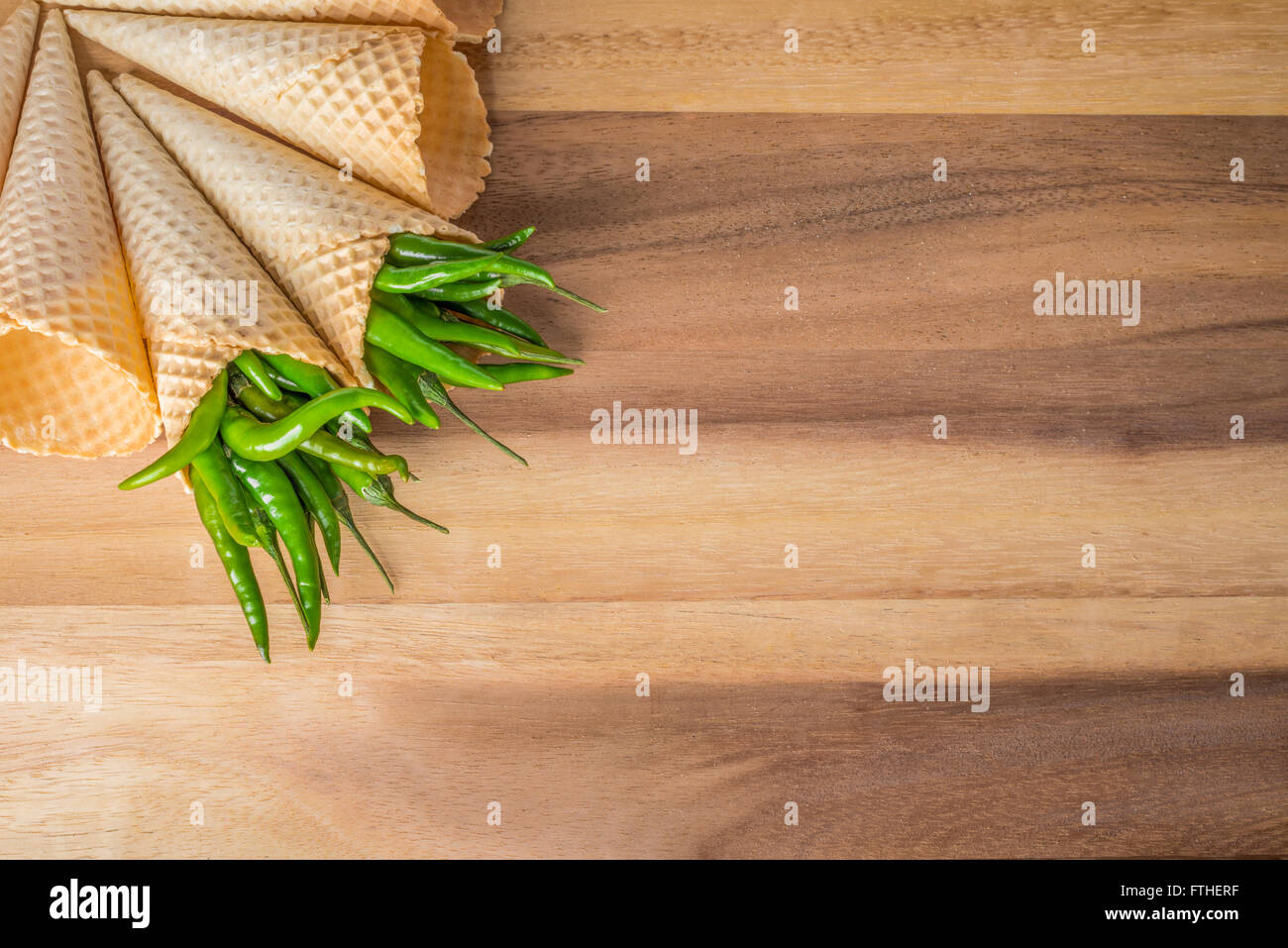 Green Hot Chili Peppers in coni su sfondo di legno Foto Stock
