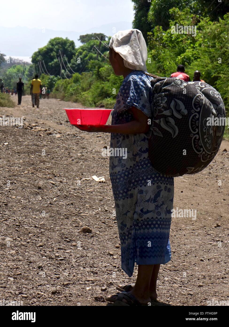 Signora etiope che tiene una piccola vasca di rosso. Foto Stock