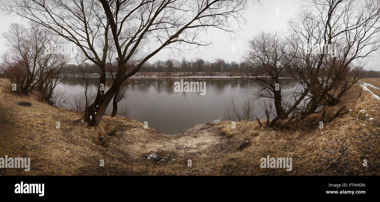 Frammenti di ghiaccio sotto il sottile strato di fiume congelato l'acqua. Blu scuro dello sfondo naturale Foto Stock