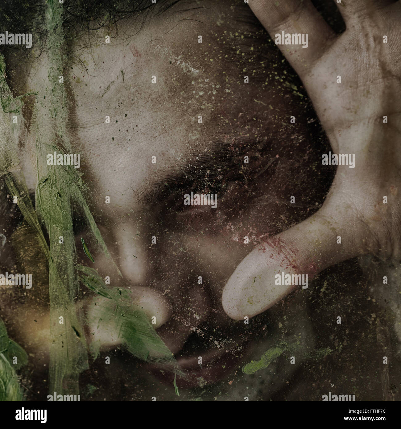 Ritratto di un giovane uomo dietro il vetro sporco Foto Stock