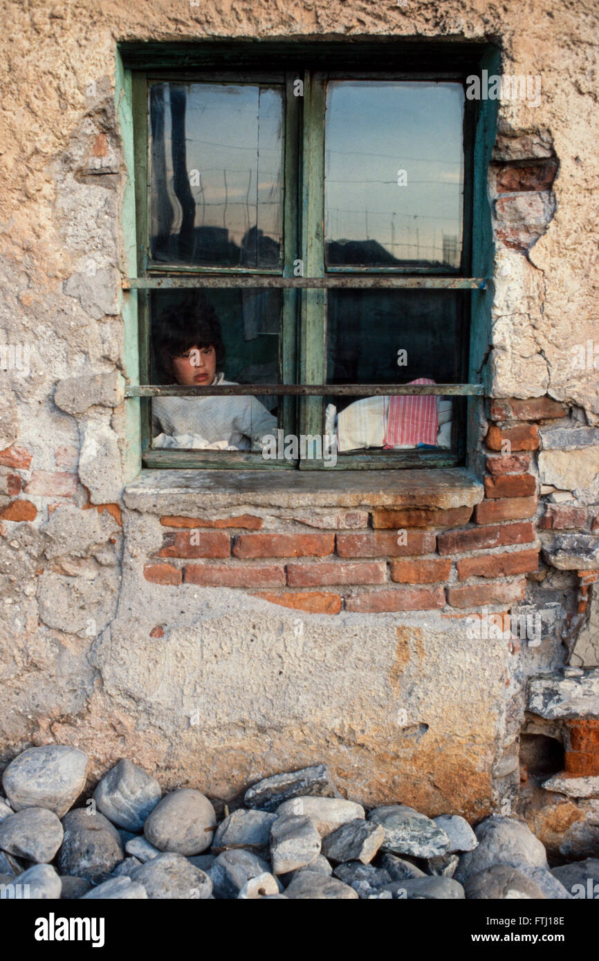 Una giovane ragazza guarda fuori dalla sua finestra, Scutari, Albania Foto Stock