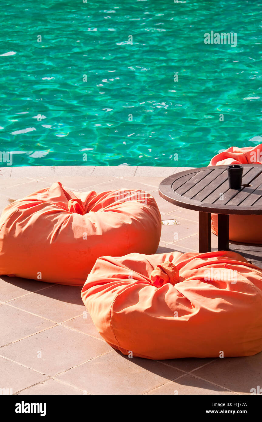 Lounge con cuscinipoufs da una piscina Foto Stock