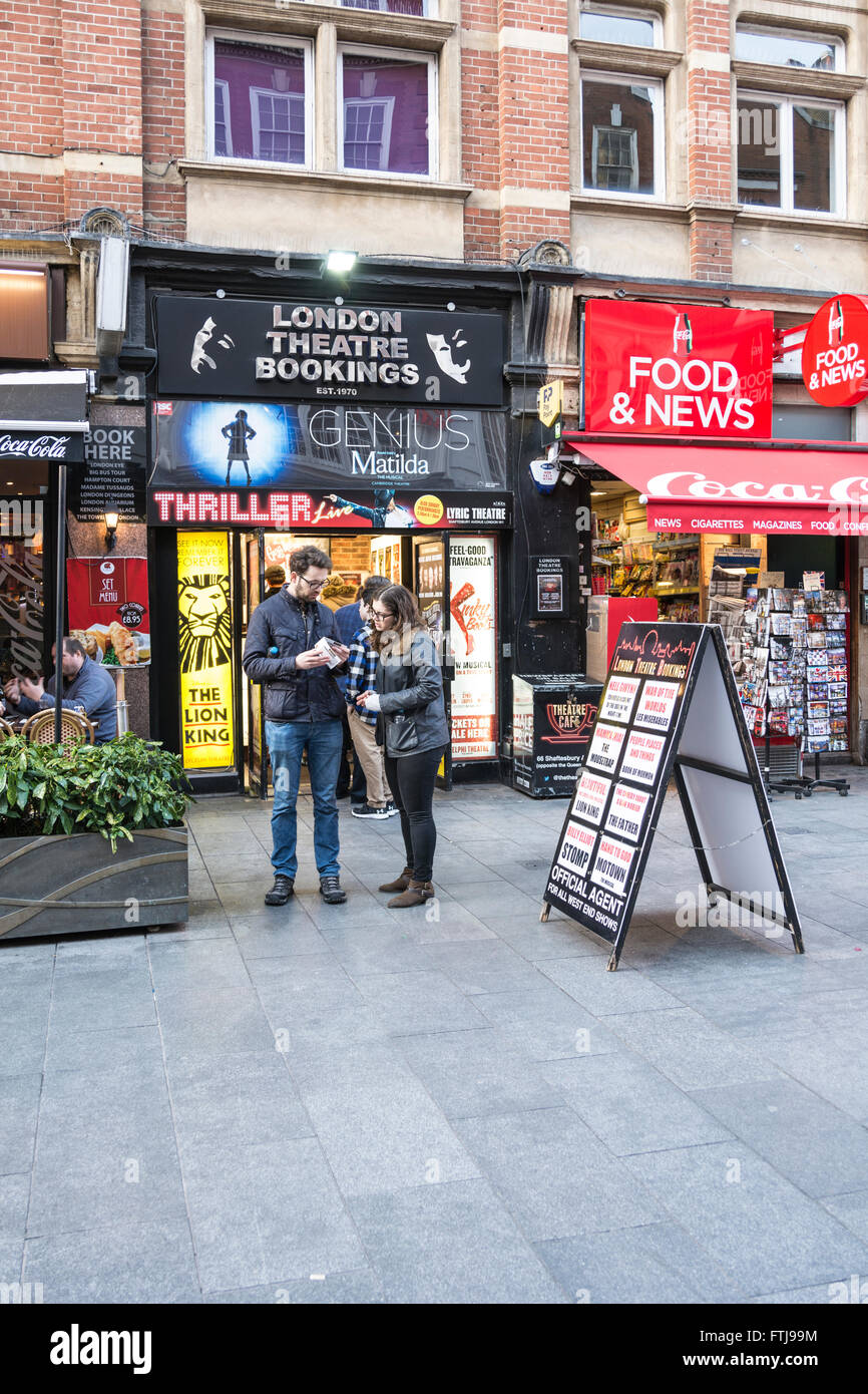 Un paio di controllare i loro biglietti da ticket booth nel centro di Londra, Regno Unito Foto Stock