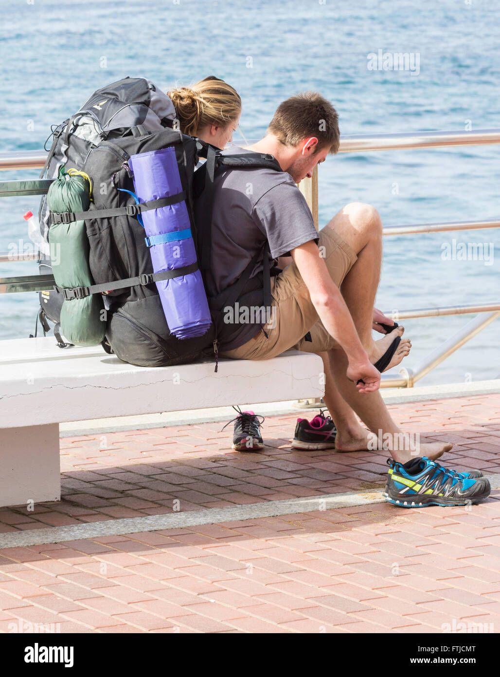 Maschio e femmina backpackers affacciato sulla spiaggia. Foto Stock