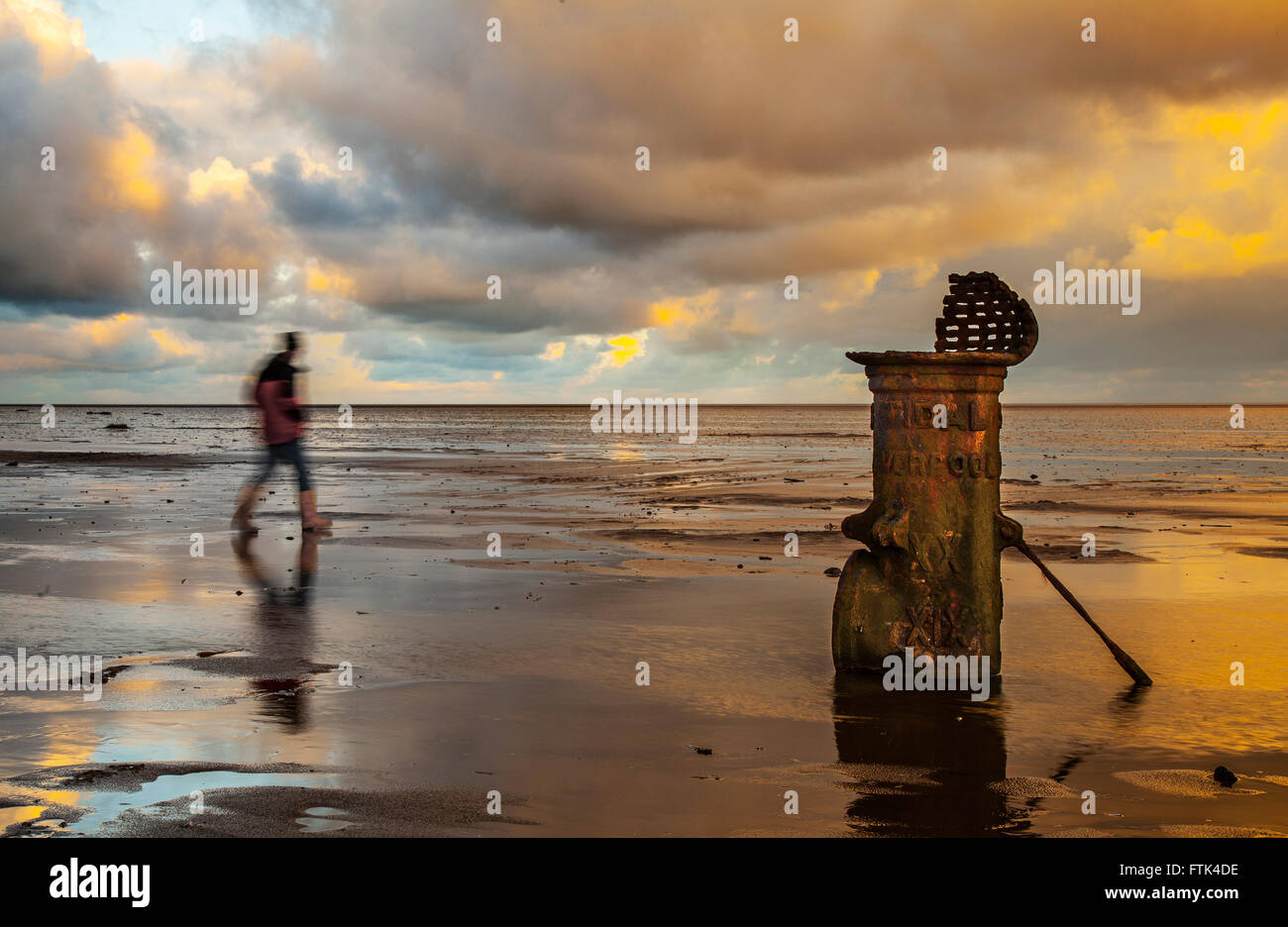 Southport, Merseyside, Regno Unito. Il 30 marzo, 2016. Regno Unito Meteo. Drammatico tramonto sul mare irlandese illuminando la 'Liverpool Fleetwood Victorian in ghisa standard di marea in acque basse. I numeri romani suggeriscono che si riferisce ad una nave con il progetto di marchi in tempi passati la marcatura di un canale di accesso alla ormai defunta e interramento porta. Foto Stock