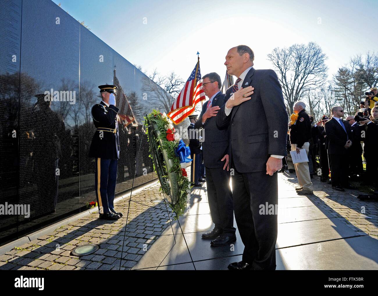 Washington, DC, Stati Uniti d'America. 29 marzo, 2016. Stati Uniti Il Segretario della Difesa Ashton Carter, destra e Segretario della Veterans Affairs Robert McDonald stand per un momento di silenzio nel corso di una cerimonia presso il Memoriale dei Veterani del Vietnam Marzo 29, 2016 a Washington, DC. I due ministri hanno onorato i morti di guerra sul al cinquantesimo anniversario del Vietnam Veterans giorno. Credito: Planetpix/Alamy Live News Foto Stock