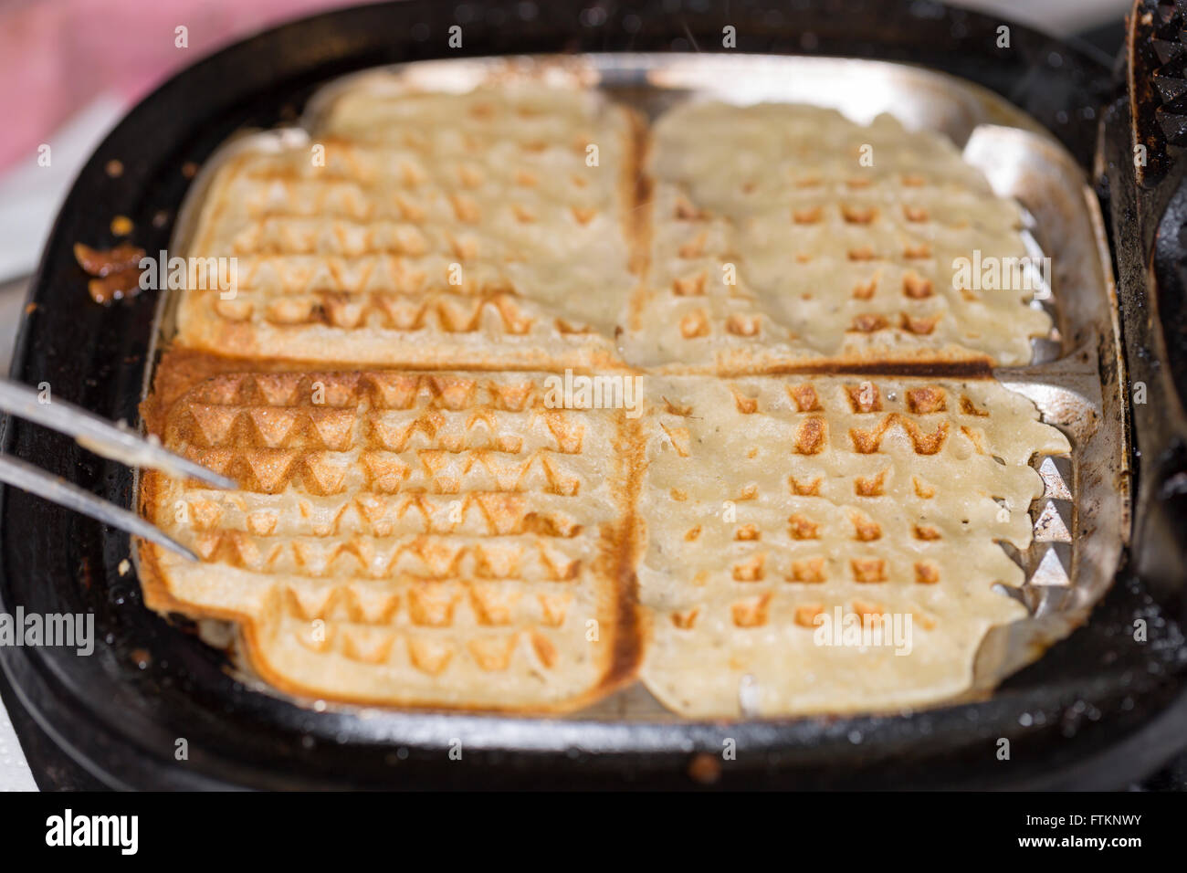 Waffle nella piastra per i waffle Foto Stock