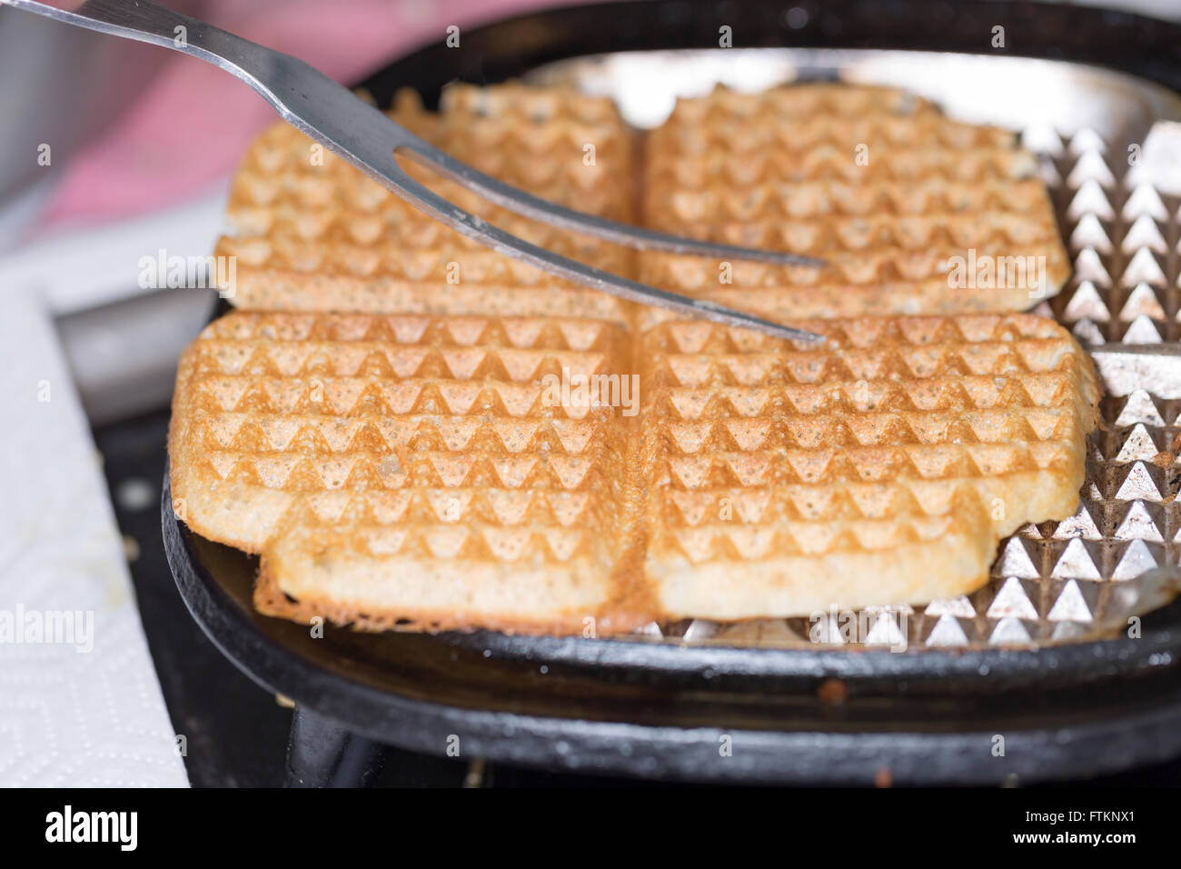Waffle nella piastra per i waffle da vicino Foto Stock