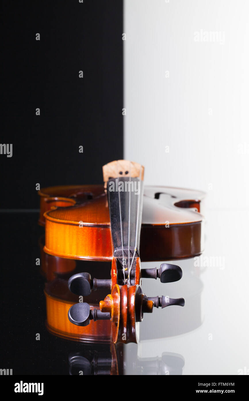 Vecchio violino isolato in bianco e nero e sfondo scrivania in vetro Foto Stock