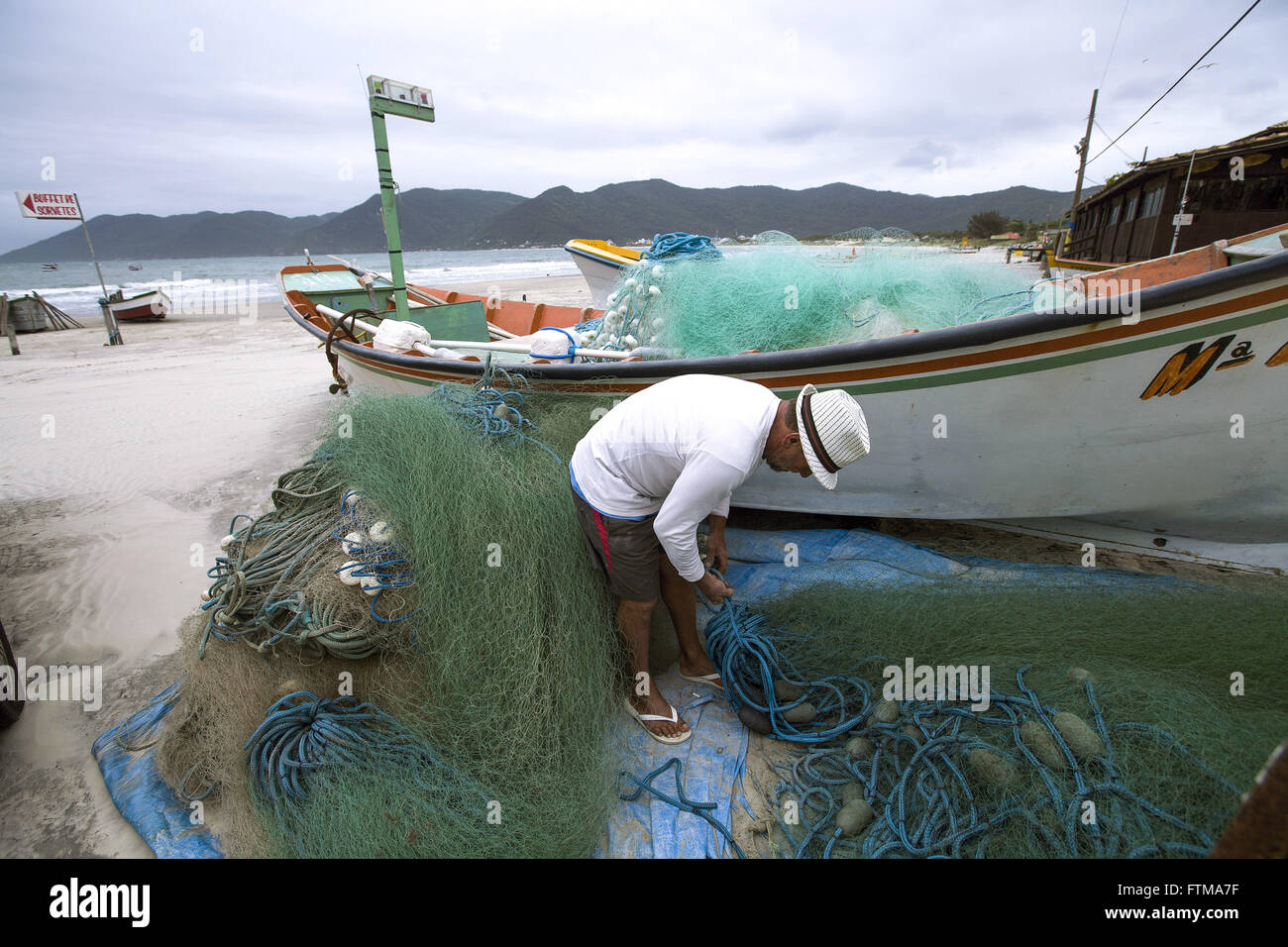 Pescador consertando rede na Praia do Pantano do Sul Foto Stock