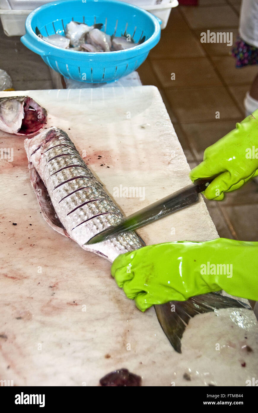 Dipendente del pescivendolo taglio triglie di pesce Foto Stock