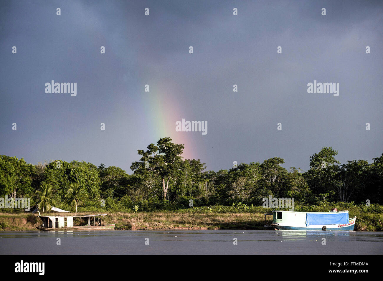Vista del Rio Purus con barche ancorate e rainbow in background nel tardo pomeriggio Foto Stock