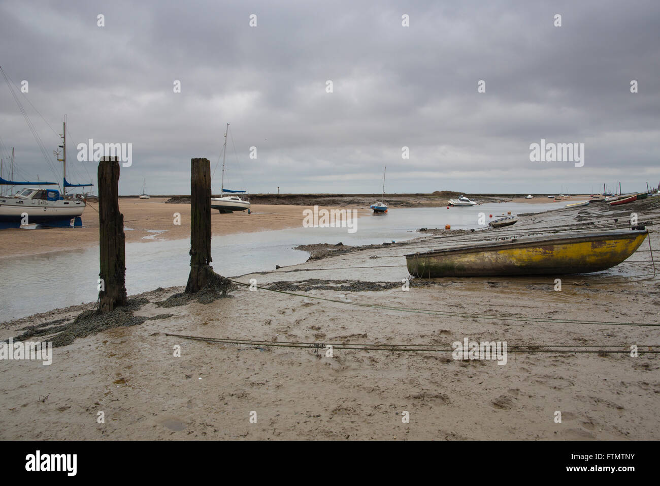 Barche ormeggiate a Wells-next-il-mare durante la bassa marea verso Blakeney, Norfolk costa East Anglia, England, Regno Unito Foto Stock