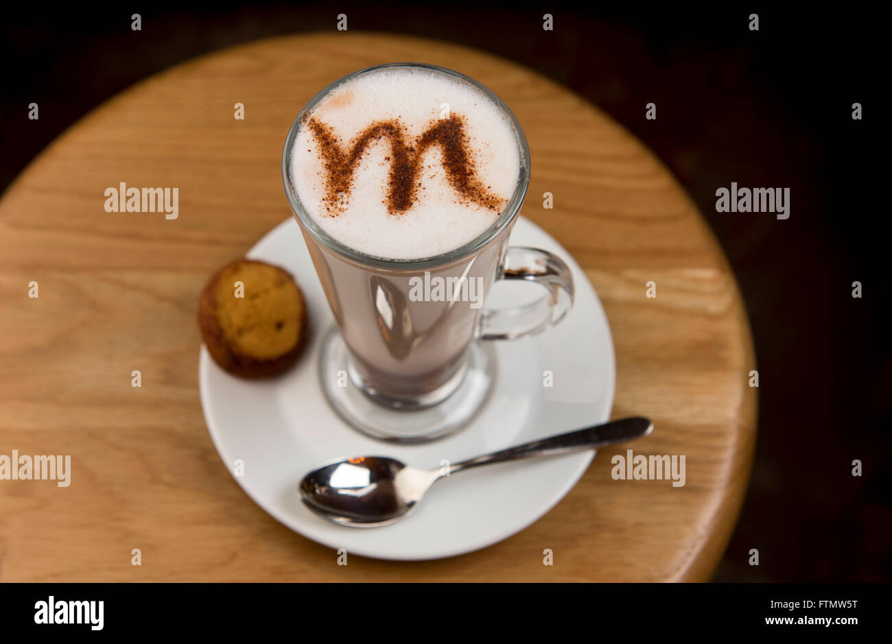 Un caffè cappuccino latte con una lettera M scritta nella schiuma di latte. Foto Stock