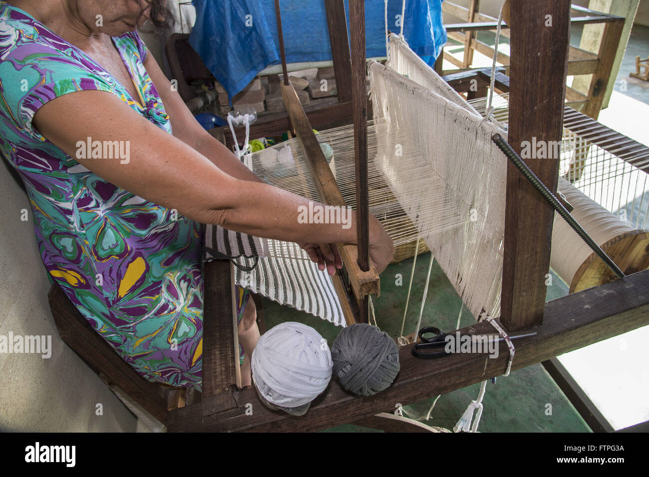 Lavorando in tessuti prodotti su telai a mano per la produzione di pezzi di artigianato tessile Foto Stock