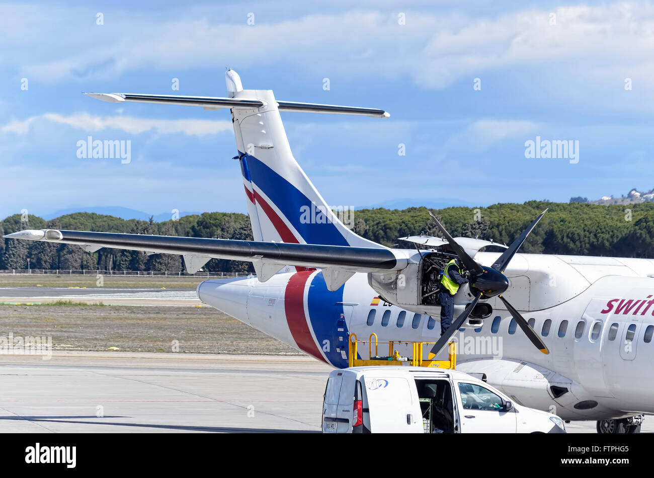 Meccanico è fare manutenzione per aereo jet -ATR 42-, di -Swiftair- compagnia aerea in aeroporto di Madrid (Spagna) Foto Stock