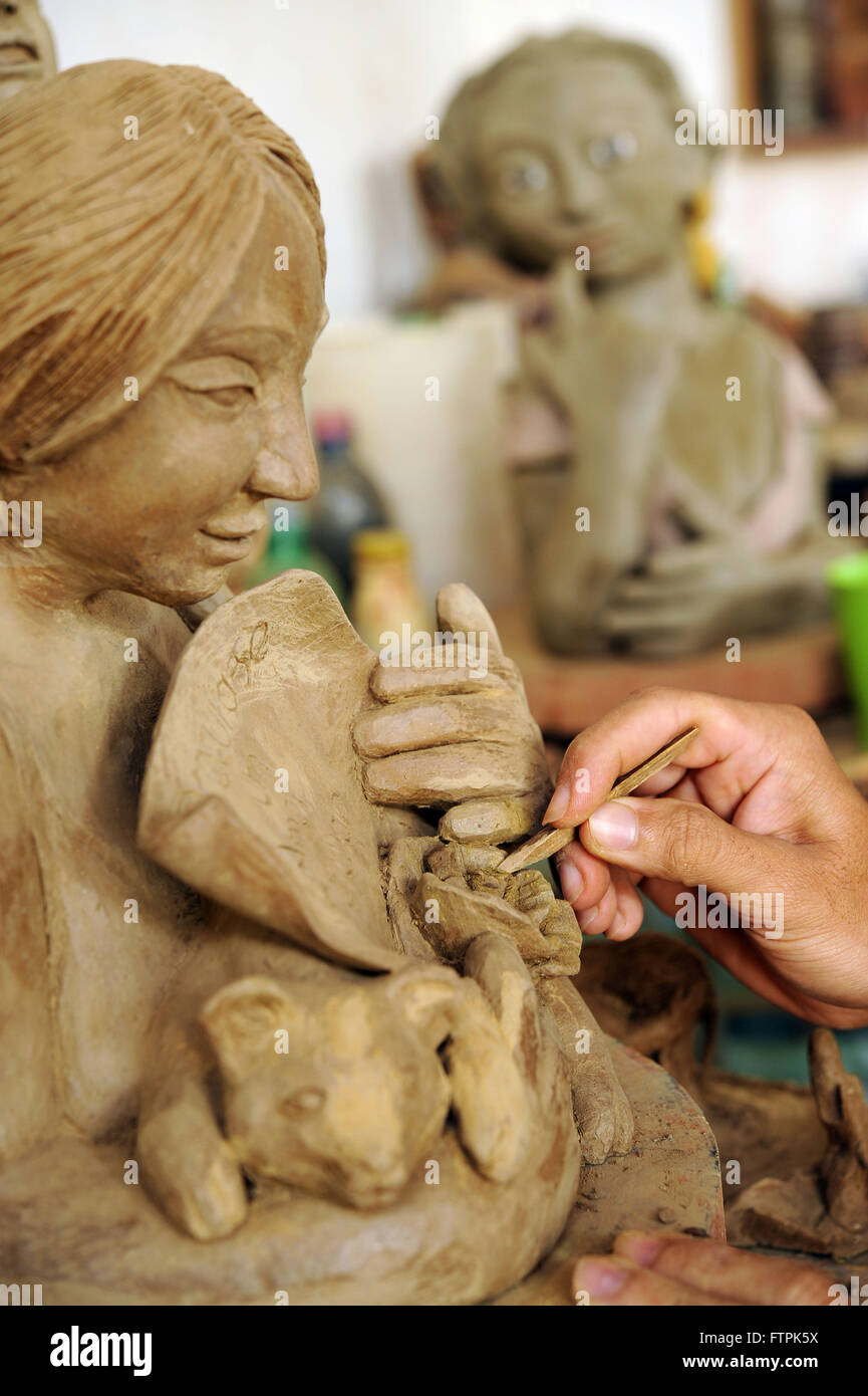 Artigiano dando finitura scultura in ceramica nella valle di Jequitinhonha Foto Stock