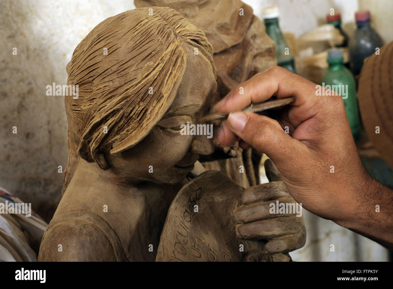 Artigiano dando finitura scultura in ceramica nella valle di Jequitinhonha Foto Stock