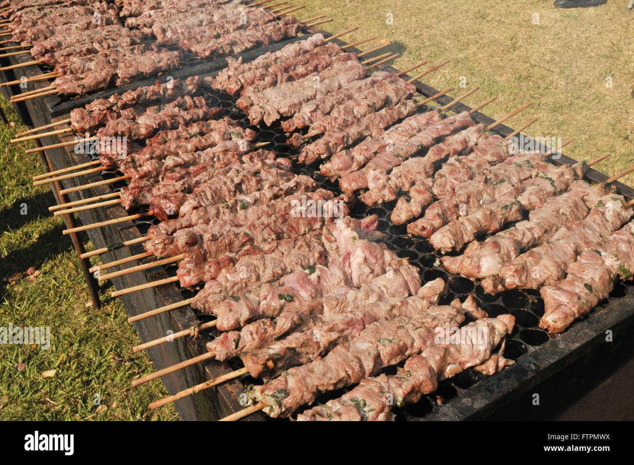 Carne grigliata su spiedini di legno su griglia di metallo su carbone.  Cottura di pollo, cuori Foto stock - Alamy