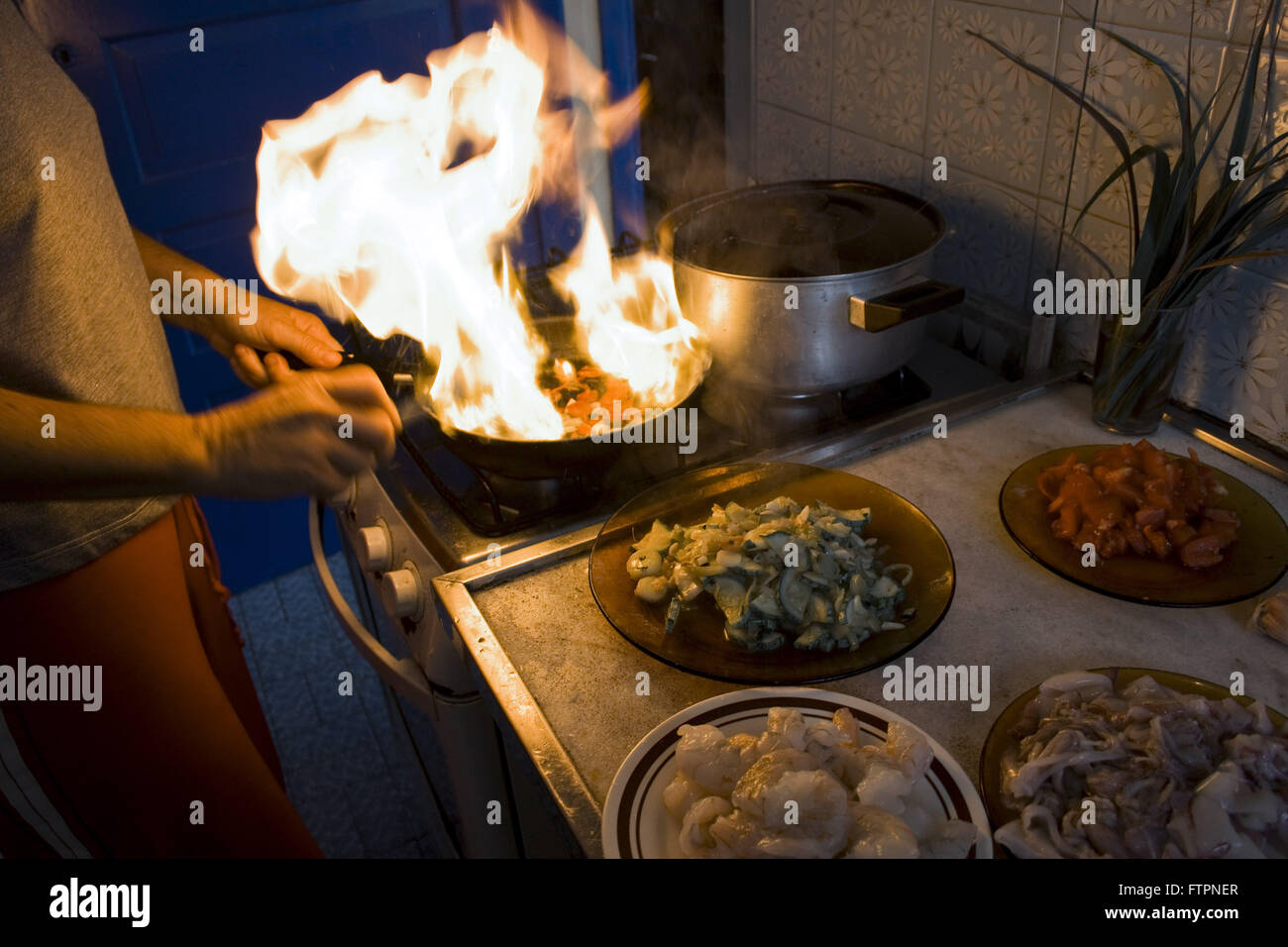 Olio per friggere a fuoco durante la preparazione di alimenti Foto Stock