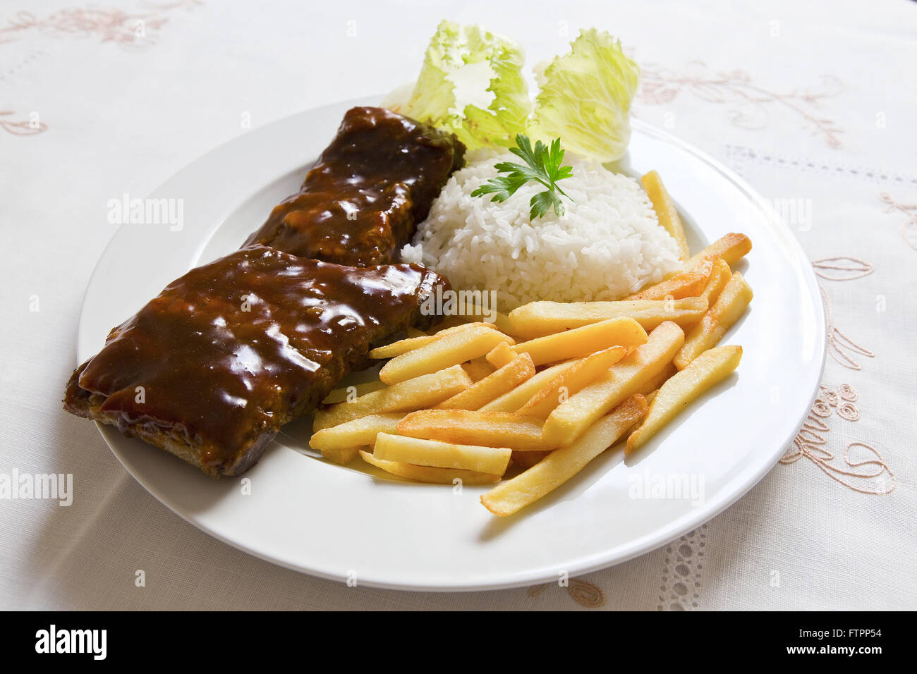 Costolette di maiale, riso, insalata e patatine fritte Foto Stock