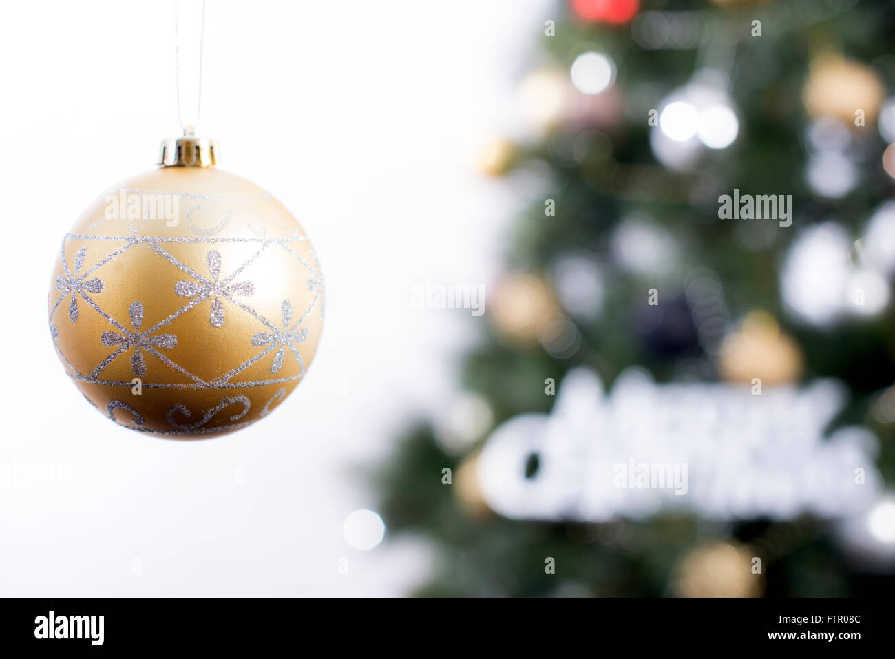 Oro Pallina natale appeso davanti a un albero. Foto Stock