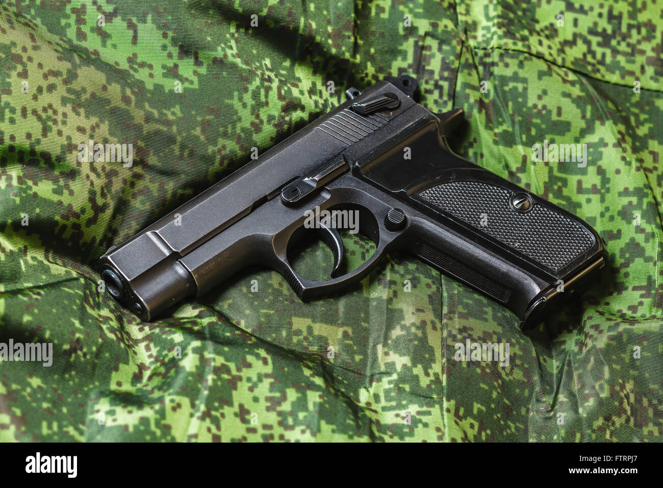 Pistola semi-automatica sul pixel di sfondo di mimetizzazione Foto Stock