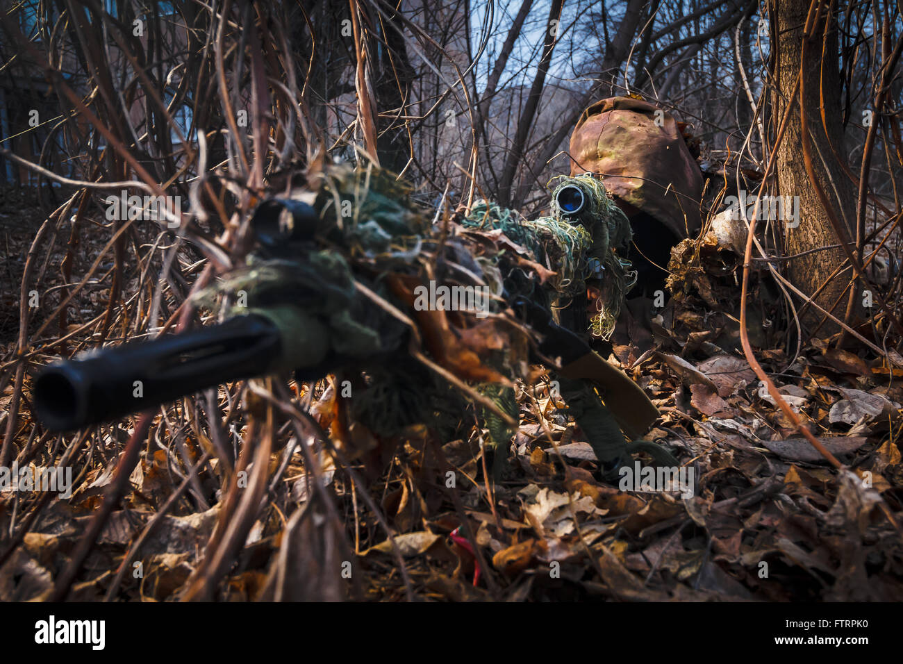 Sniper indossare tuta mimetica con un fucile nascondere nel bosco Foto  stock - Alamy