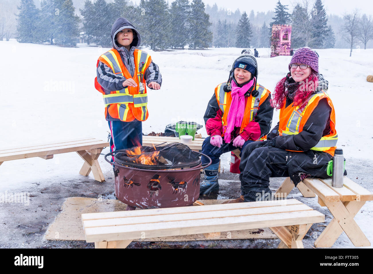 I lavoratori in fase di riscaldamento dal fuoco, Silver Skate Festival, Hawrelak Park, Edmonton, Alberta, Canada Foto Stock