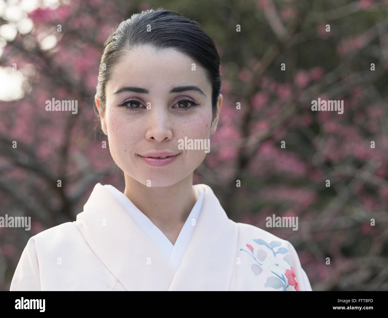 Young ( Asian / Caucasian ) Japanese woman in kimono with cherry blossom. Foto Stock