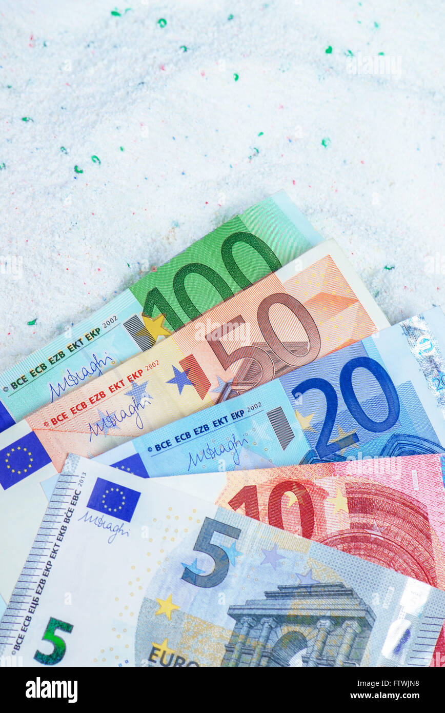 Risparmio di denaro sulla qualità conveniente il detersivo in polvere, le banconote in euro in detergenti per bucato. Foto Stock