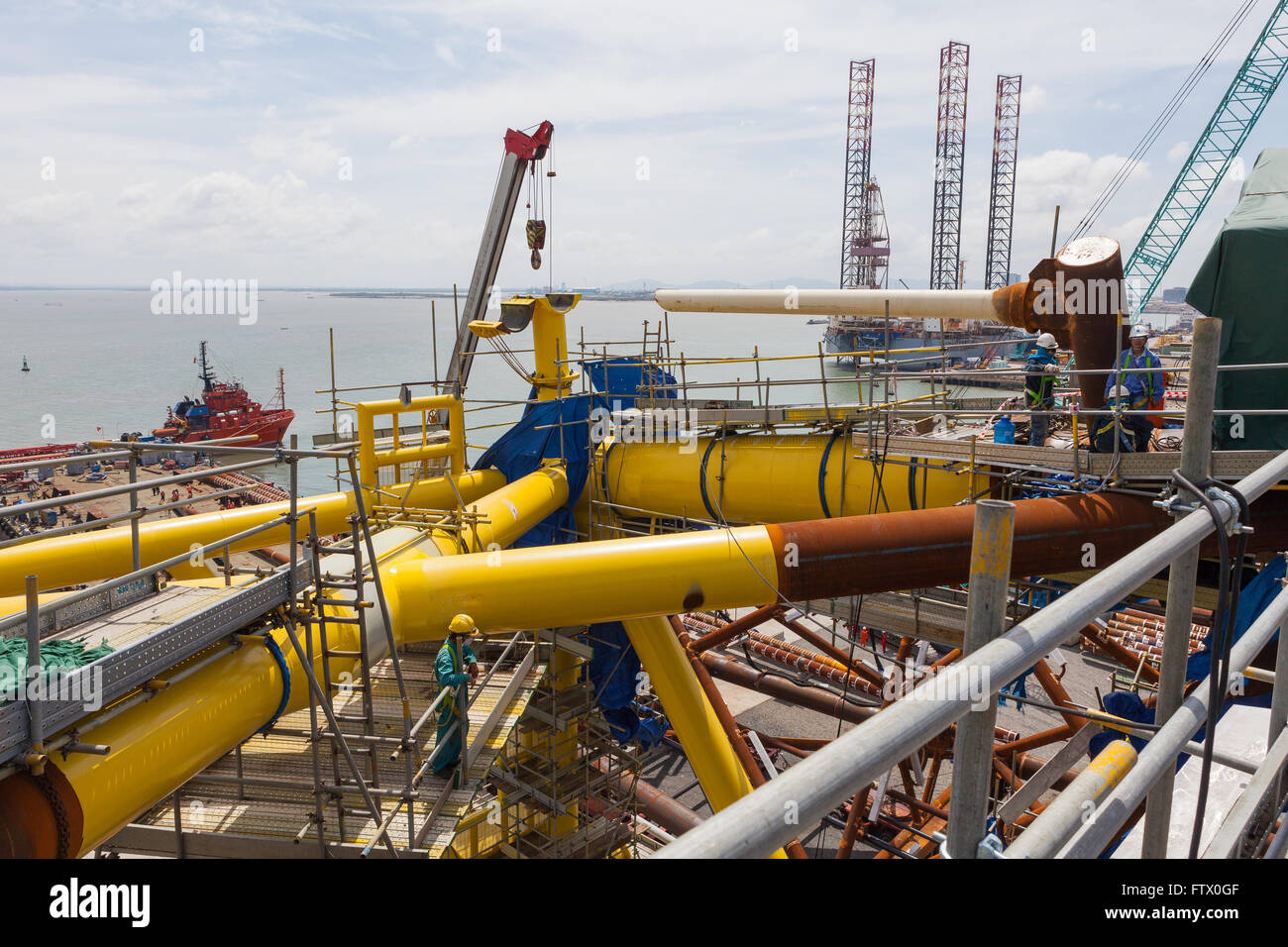 Uomini al lavoro su una piattaforma petrolifera sito in costruzione Foto Stock