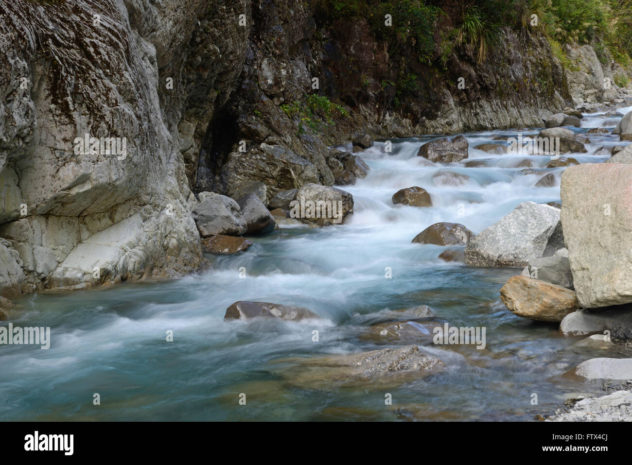 Una neve-alimentato Nuova Zelanda flusso scorre attraverso l'Arthur's Pass nell'Isola del Sud Foto Stock