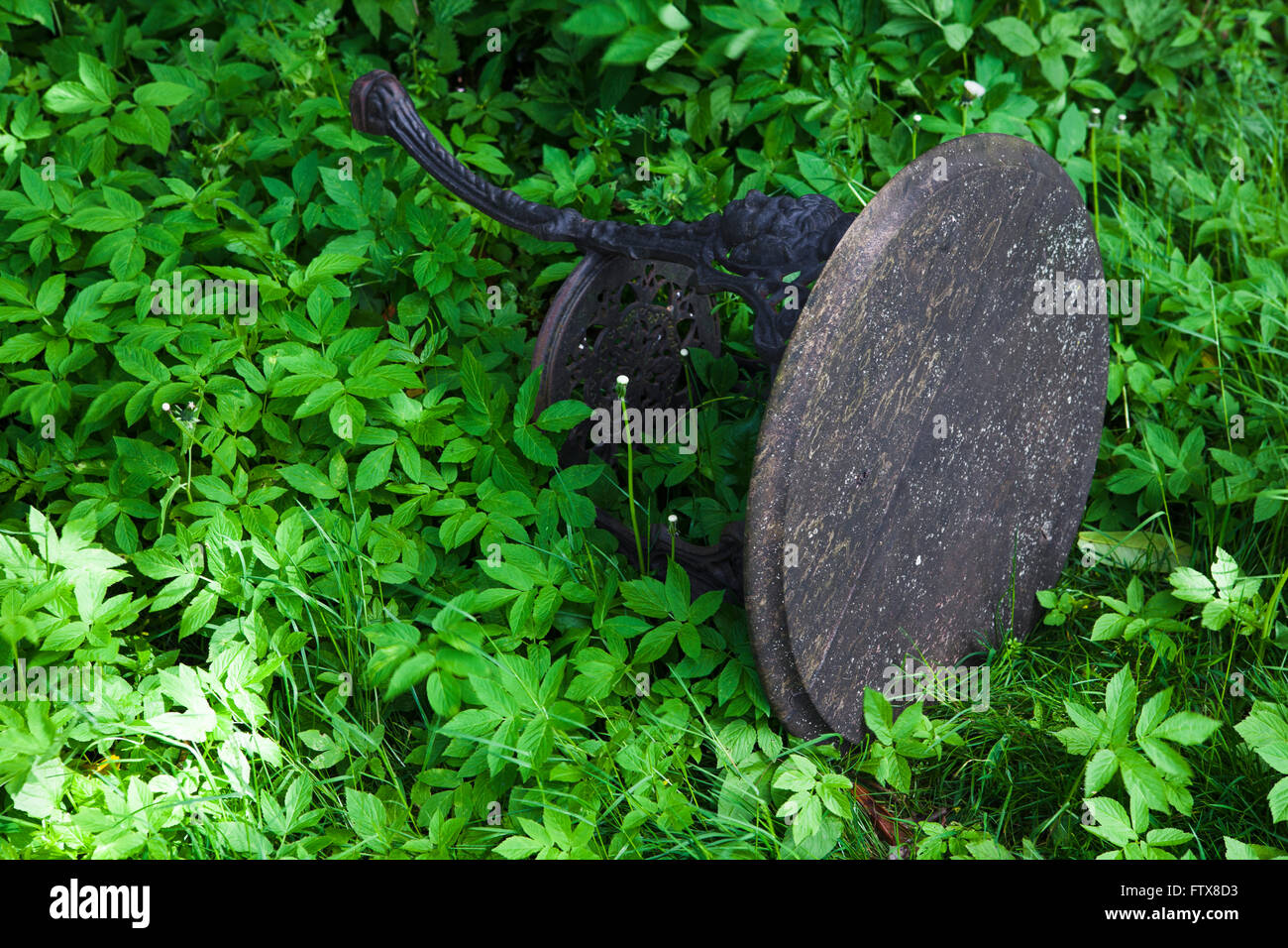 Vecchi mobili da giardino realizzati in ferro etc seduto in un giardino sovradimensionate. Foto Stock