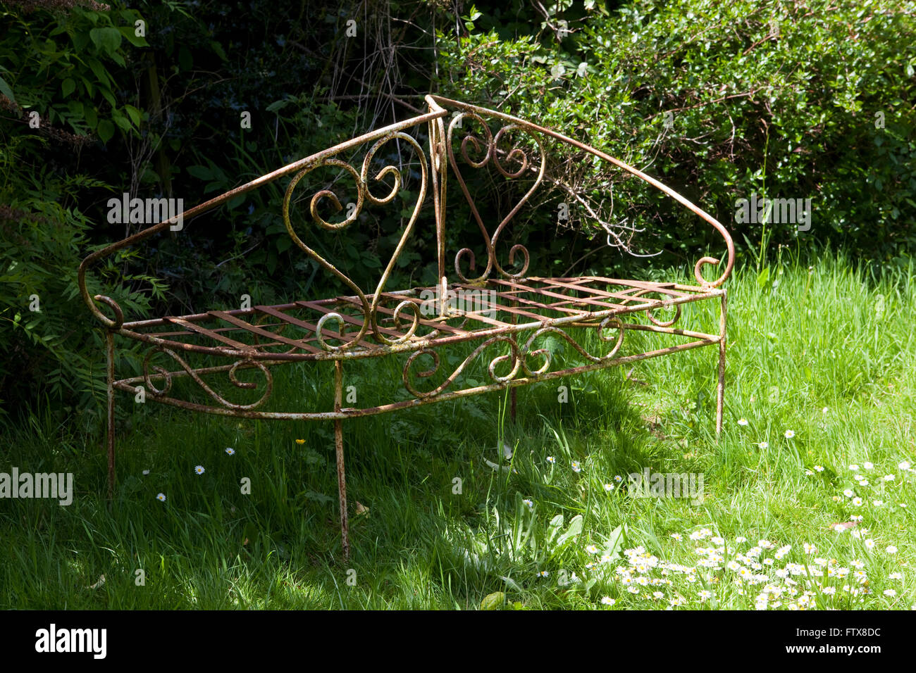 Vecchi mobili da giardino realizzati in ferro etc seduto in un giardino sovradimensionate. Foto Stock