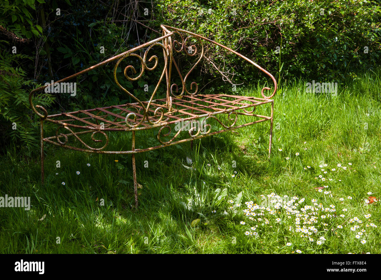 Vecchi mobili da giardino realizzati in ferro etc seduto in un giardino sovradimensionate. Foto Stock