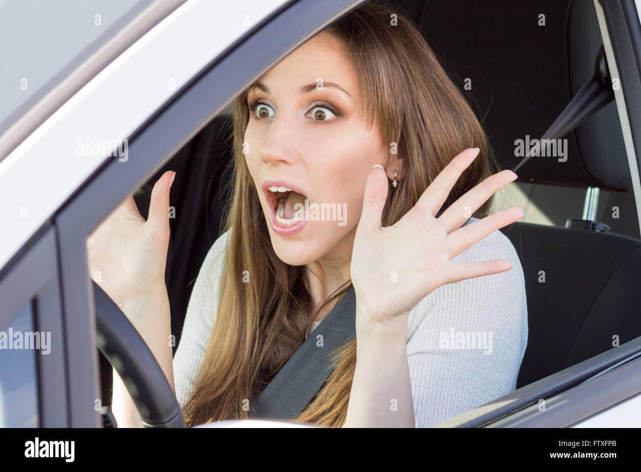 Frightened young driver di automobile di donna che guarda dritto. Scioccato bellezza ragazza in auto Foto Stock