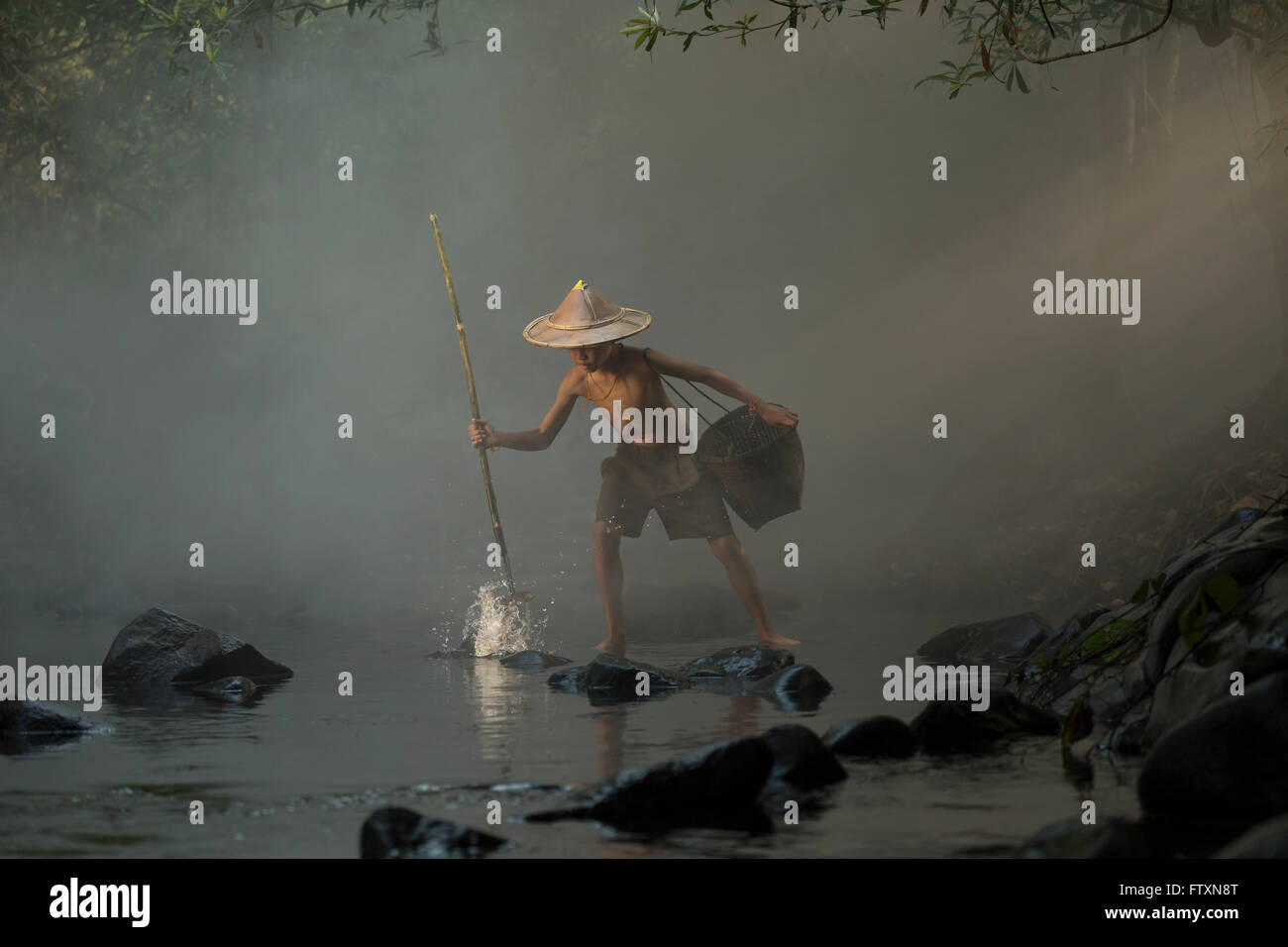 Giovane ragazzo di pesca con una lancia di Nong Khai in Thailandia Foto Stock