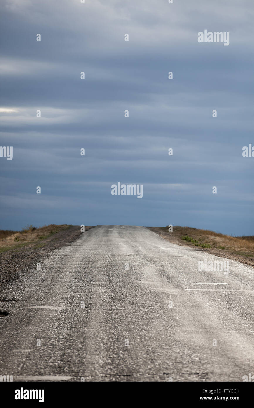 Kazakistan, Kazakistan,Asia, una sporca strada in direzione del cielo nuvoloso. Foto Stock