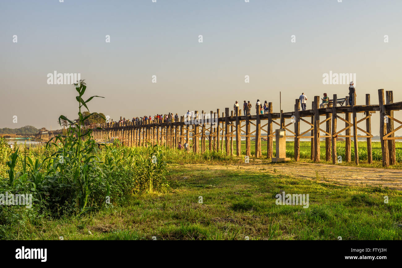 La gente che camminava sul legno storico U Bein Bridge al tramonto Foto Stock